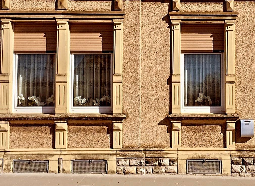 3 windows of a yellow house in Luxembourg.