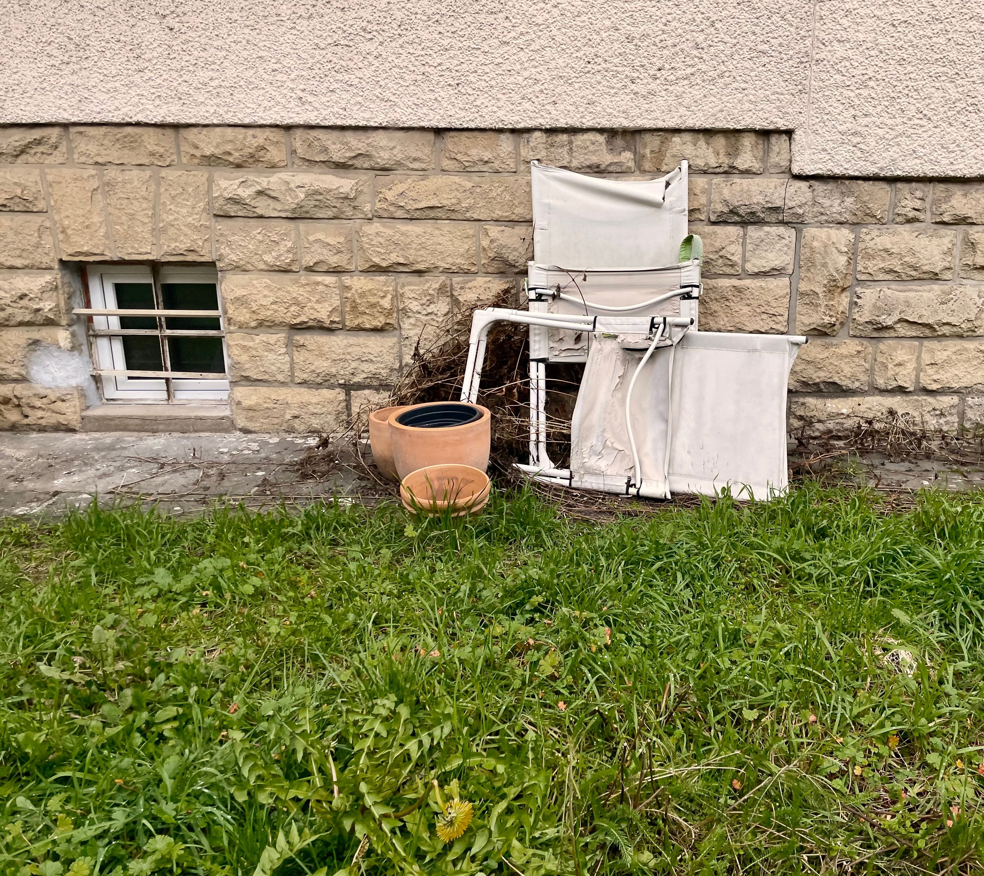 White chairs leaning on a wall with vases, Luxembourg.