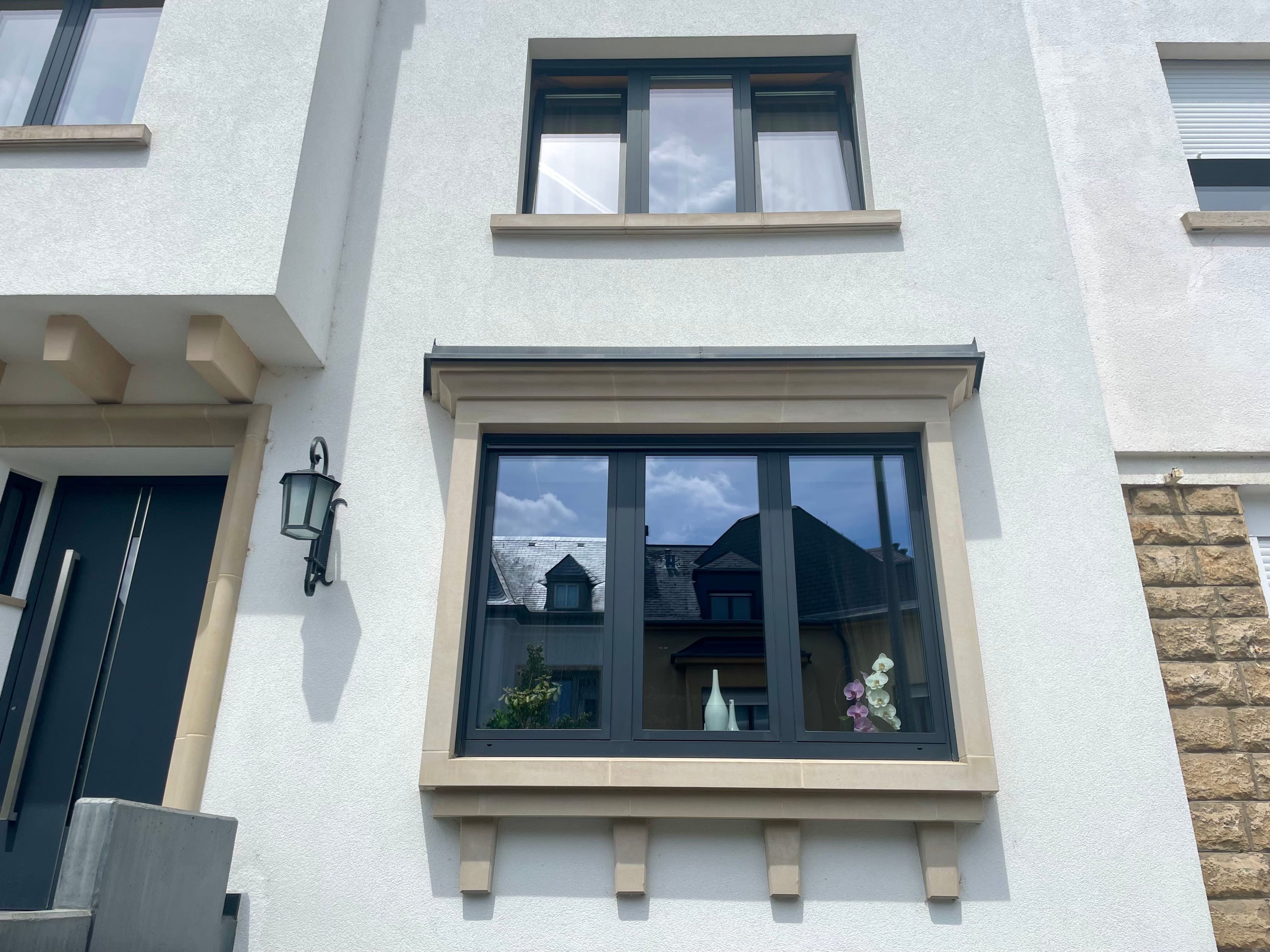 4 windows and a door of a white house, in Luxembourg.