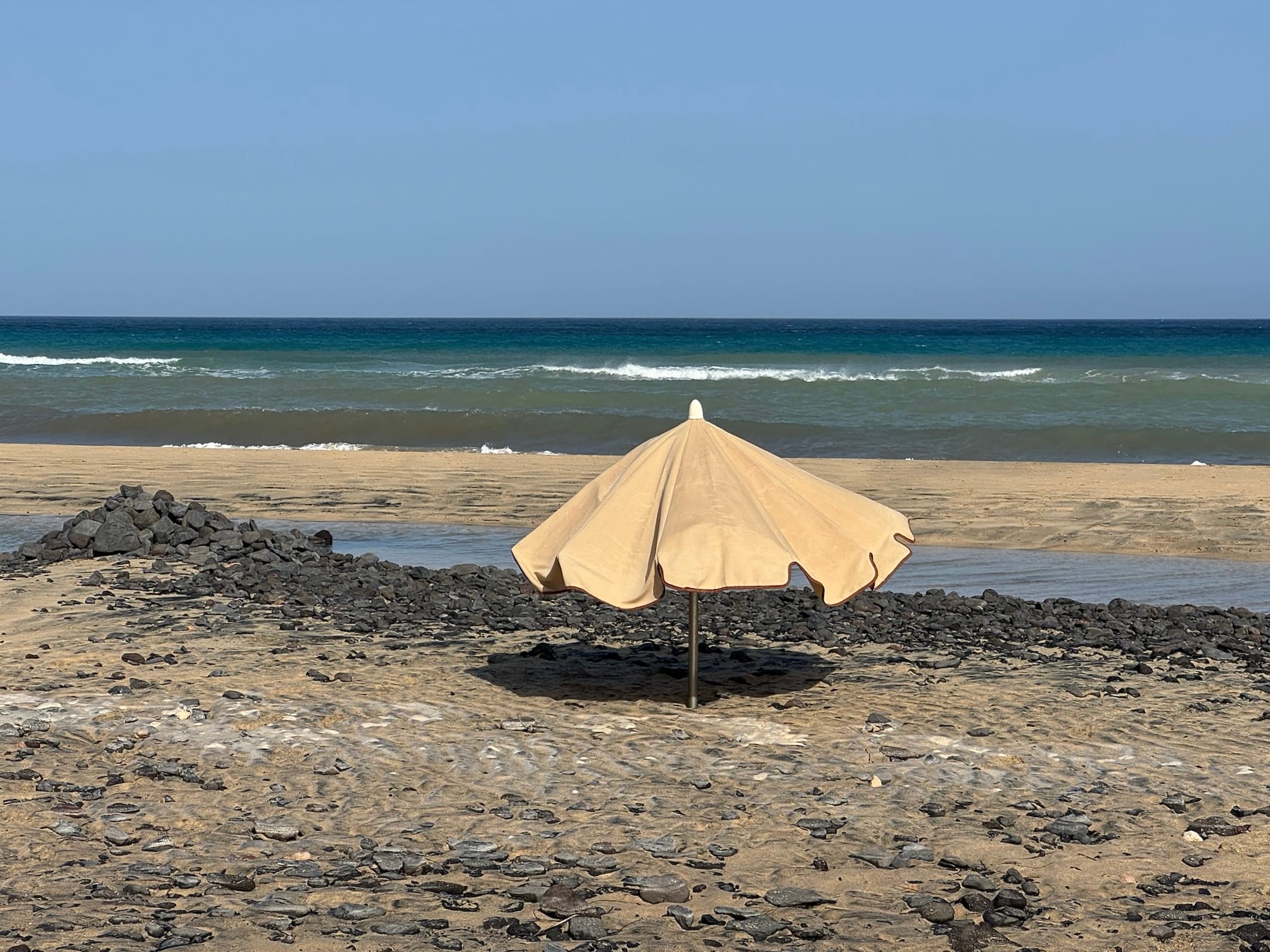 Yellow parasol on Playa del Mal Nombre, in Fuerteventura, Spain.